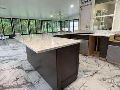 Waterfall island countertop in sunroom-style kitchen